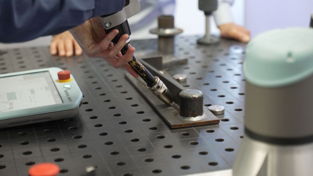A welder teaching welding cobot the path it should follow during welding using freedrive mode on SmoothTool welding software