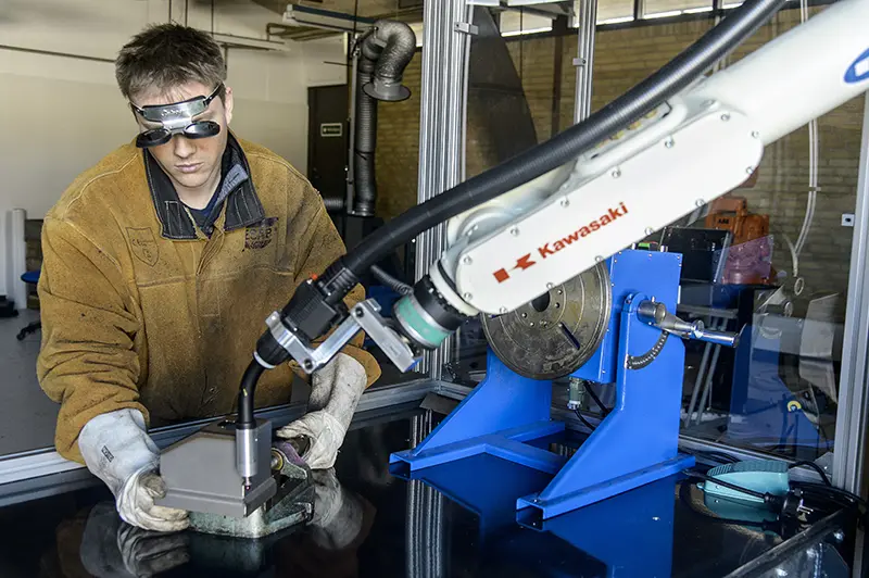 Selecting the Right Robotic Welding System for Your Business 2 example of robotic welding systems showing an operator positioning a welding piece