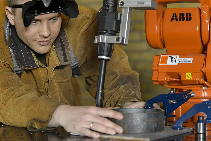 Selecting the Right Robotic Welding System for Your Business 4 An example of an industrial robotic welding system with an operator lining up the weld piece