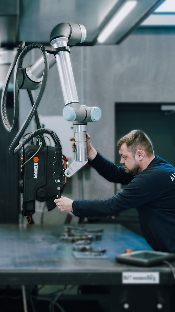 A welder with a welding cobot performing welding tasks in company workshop